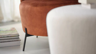 Détail d'un pouf Mobitec Bolero rouille et d'un fauteuil blanc