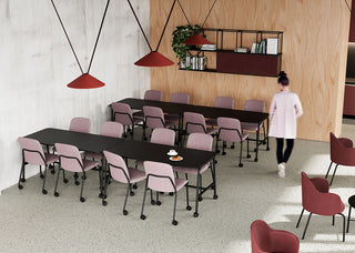 Photo d'ambiance de chaises Bejot Hens roses à de longues tables dans une cantine avec suspensions rouges