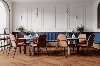 Photo d'ambiance de chaises Bejot Hens roses et en bois dans un restaurant avec banquette bleue
