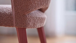 Detail van de roze bouclé rug van een Mobitec Cuori stoel met roze poten