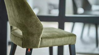 Détail d'une chaise Mobitec Lena en velours vert olive à dossier ajouré