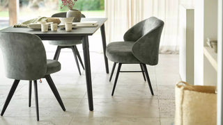 Photo d'ambiance de chaises Mobitec Neo vertes à pieds noirs autour d'une table sombre