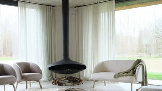 Photo d'ambiance de fauteuils et banquette Mobitec Thalia gris autour d'une cheminée suspendue