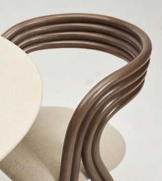 Detail van de gebogen rotan rugleuning van de Vincent Sheppard Arc Dining Chair aan een ronde tafel