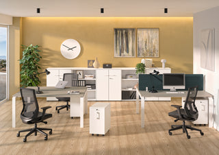 Lifestyle image of a white Buronomic Comfort slim pedestal by workstations with green screens