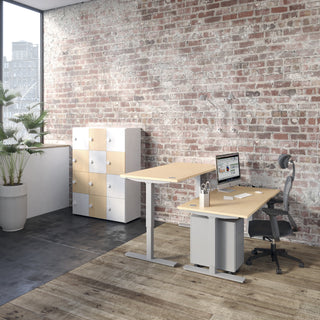 Sfeerbeeld van een Buronomic Locker Eko kast met twaalf vakken in wit en beuk naast een zit-sta bureau