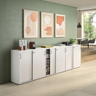 White Buronomic Quietude 104 cm sliding door cabinets with black handle against a green wall