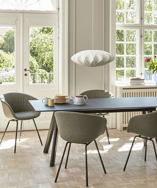 Photo d'ambiance d'une table HAY CPH 30 avec chaises vertes devant des portes-fenêtres