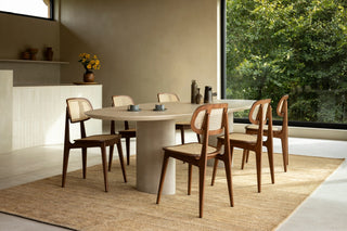 Sfeerbeeld van Vincent Sheppard Titus eetstoelen in tobacco oak rond een ovale tafel op jute tapijt