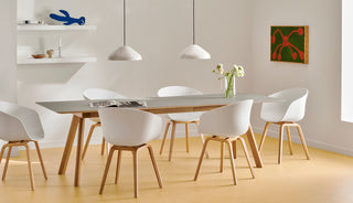 Photo d'ambiance d'une table HAY CPH 30 en chêne avec chaises blanches sous trois suspensions