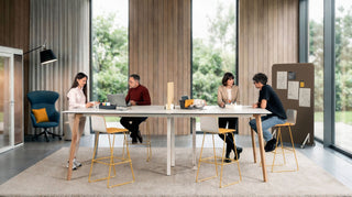 Sfeerbeeld van een lange witte König + Neurath CONNECT.BENCH tafel in een hoge ruimte met grote ramen