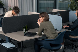 Sfeerbeeld van König + Neurath CONNECT.BENCH werkplekken met grijze schermen en blauwe bureaustoelen