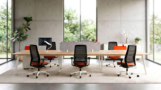 König + Neurath CONNECT.BENCH projecttafel met oranje schermen en drie zwarte bureaustoelen bij ramen