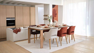 Photo d'ambiance de chaises Mobitec Lena blanches et rouille à une table en bois dans une cuisine ouverte