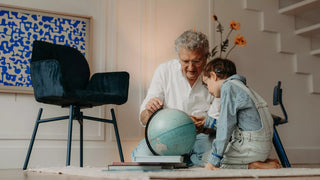 Photo d'ambiance d'un grand-père et d'un enfant avec un globe près d'une chaise Mobitec Mood bleu pétrole