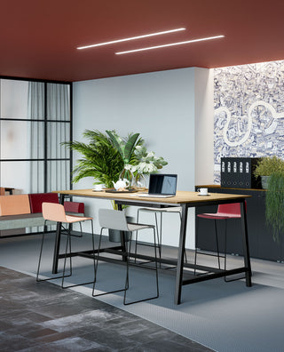 Hoge Frezza Pop ace tafel met zwart frame en eiken blad onder een rood plafond