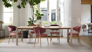 Photo d'ambiance de chaises Mobitec Toro roses à une longue table en bois dans un espace lumineux