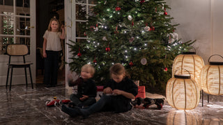 Sfeerbeeld van kinderen bij een kerstboom met een Vincent Sheppard Titus stoel en lantaarns